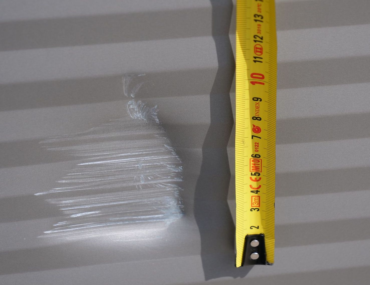 Ein gelbes Maßband mit den Zahlen 2 bis 13 darauf