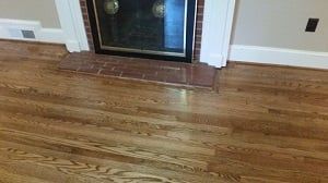 A living room with hardwood floors and a fireplace.