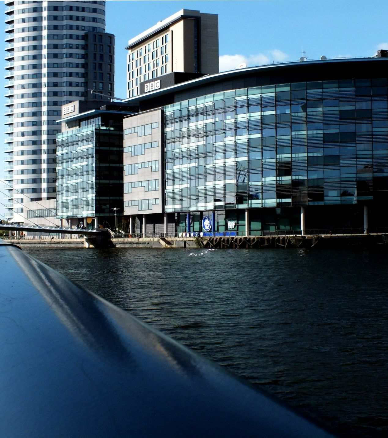 a large building with a lot of windows is next to a body of water