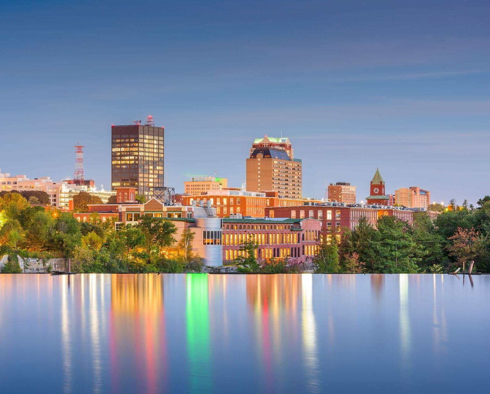 a city skyline is reflected in a body of water .