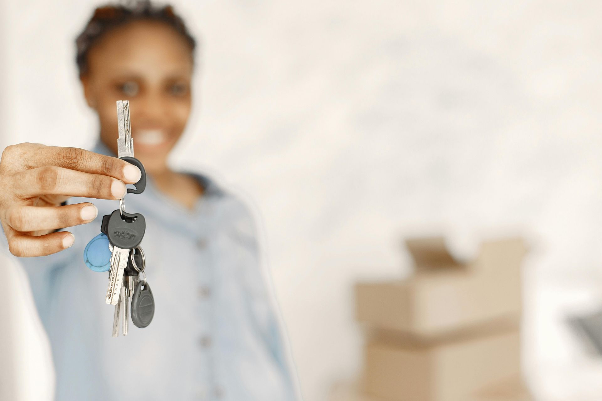 Person holding set of keys forward with a blured background