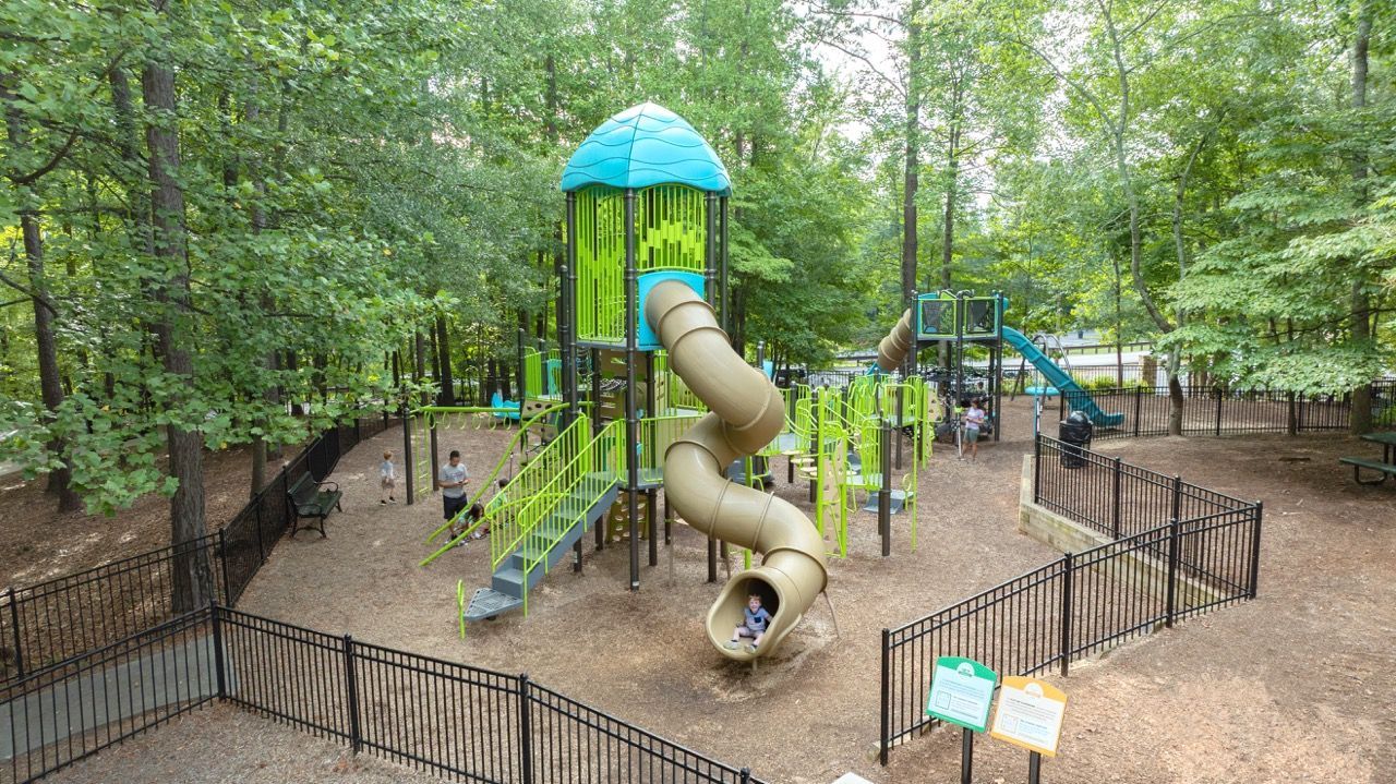 Composite play structures with multi-level decks and slides