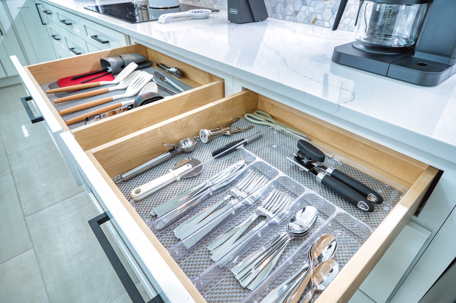 Kitchen drawer with organized utensils in wooden dividers beside a countertop