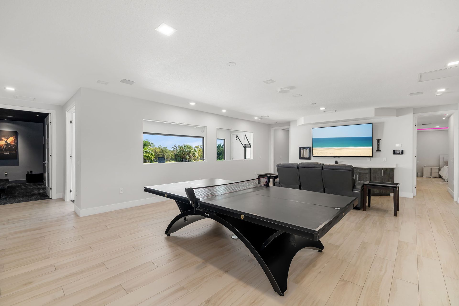 Modern open living room with black coffee table, gray sofa, wall art, and ocean-view windows