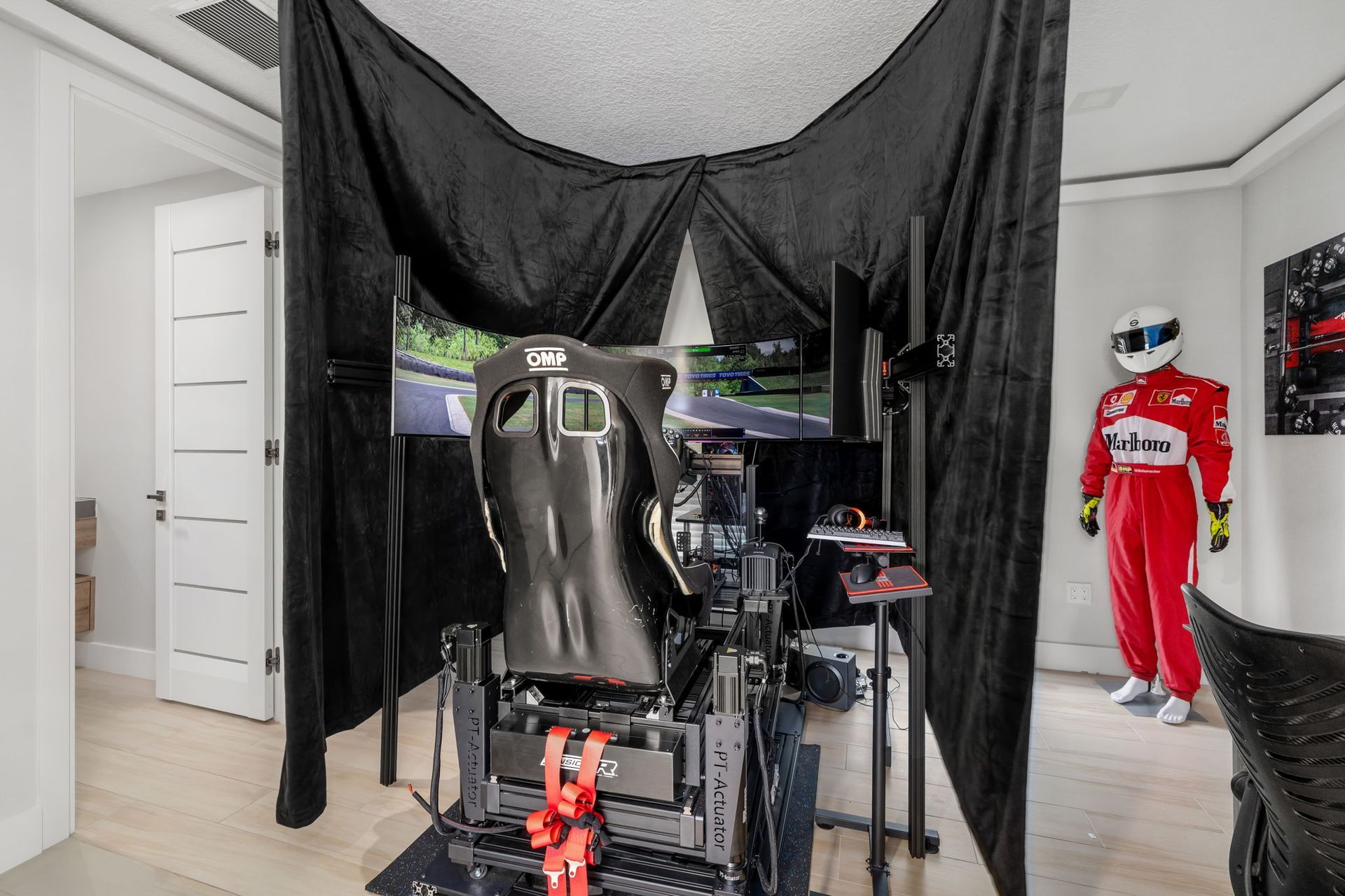 Home gym with a racing simulator seat, equipment racks, and a red Coca-Cola mannequin near the wall