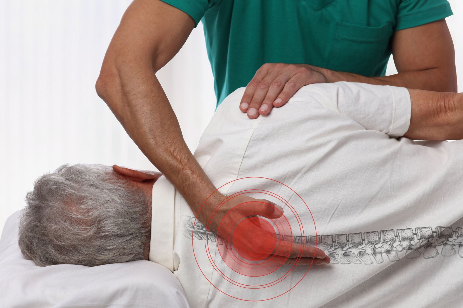 Person receiving back massage, therapist's hand on lower back with pain indicator.