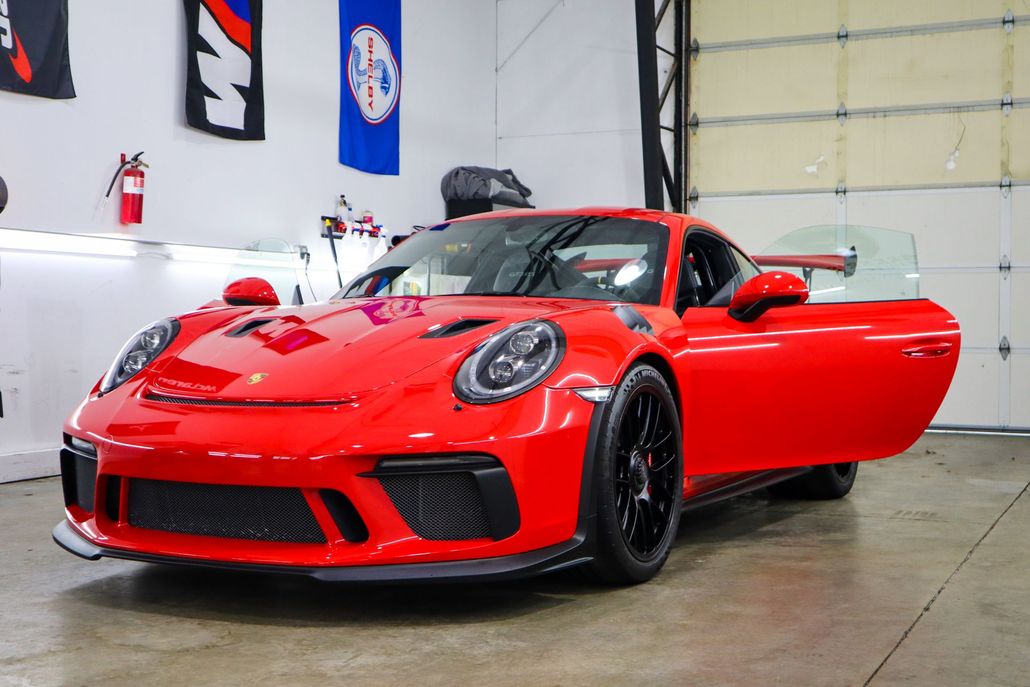 A red car parked inside the shop