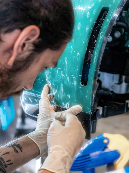 a man wearing gloves is working on a car