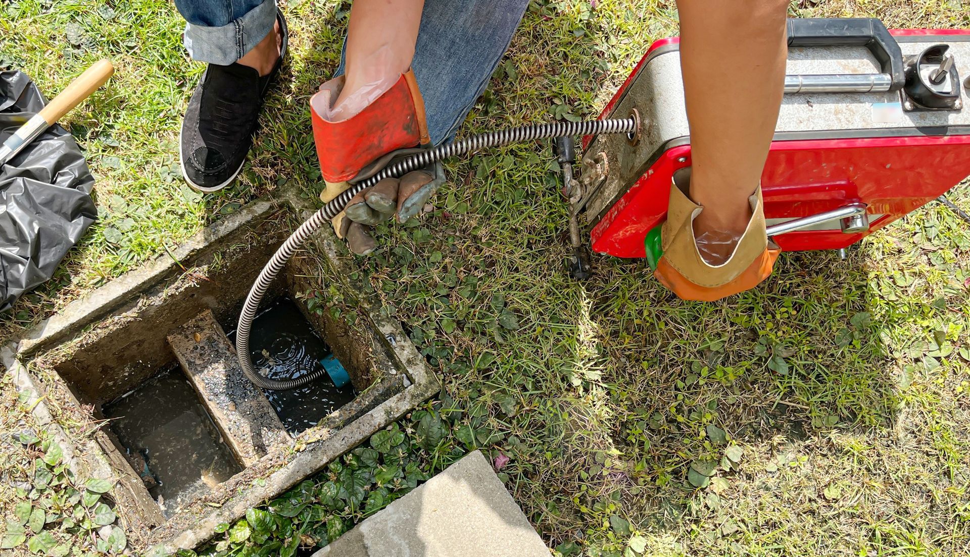 A person is using a machine to clean a drain.