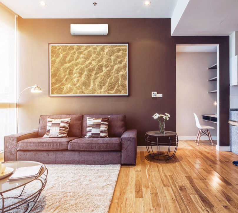 Living room with a purple couch, painting of water, and wood flooring.