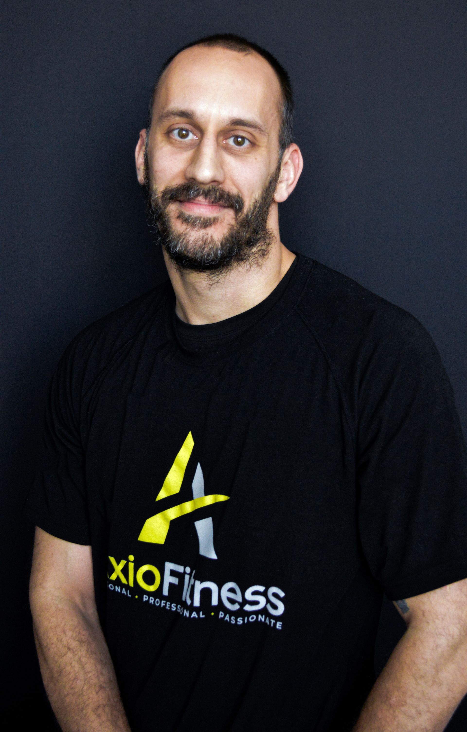 Man with beard wearing a black t-shirt with a yellow and silver