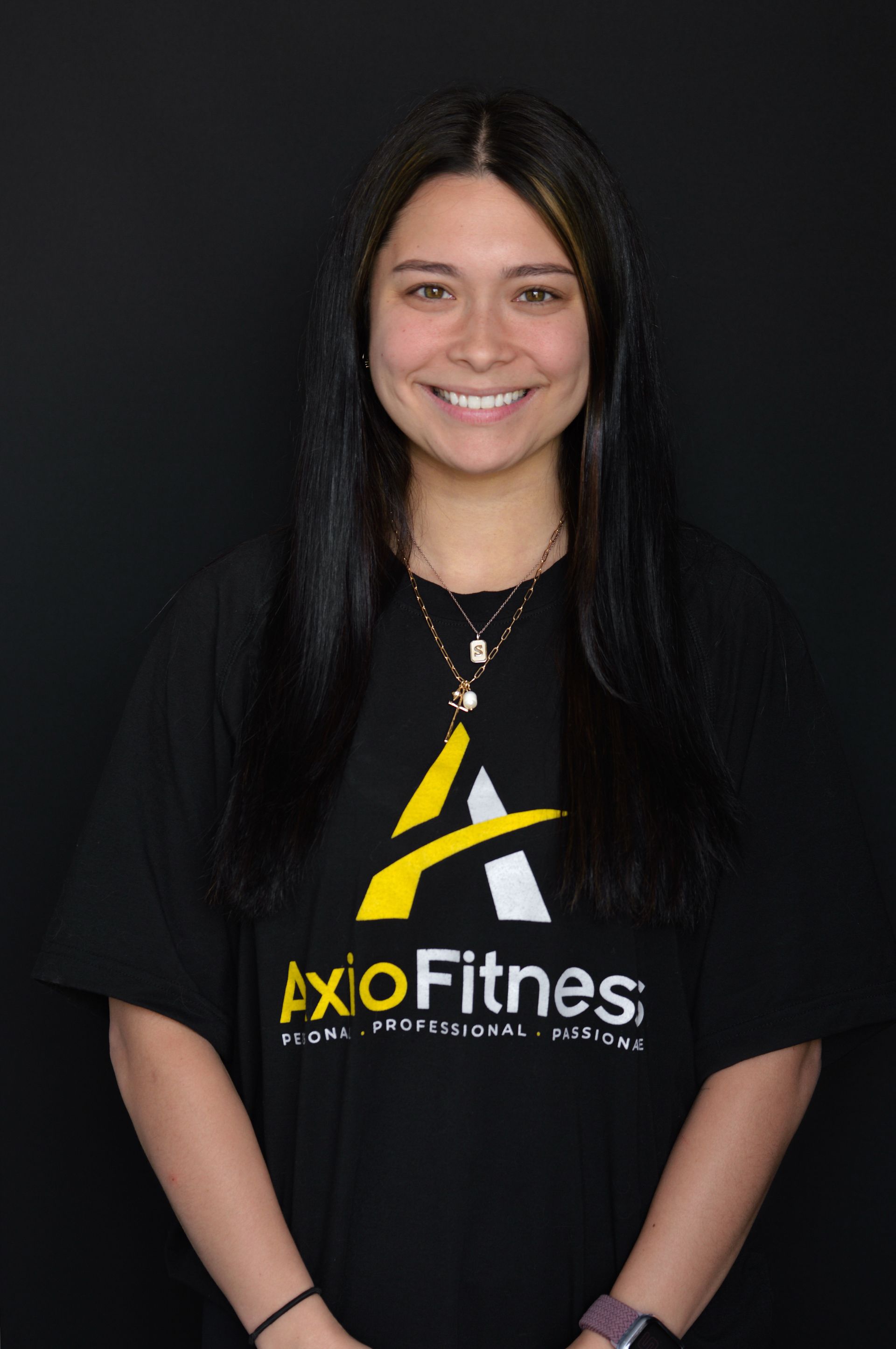 Smiling person in black LioFitness T-shirt against a dark background