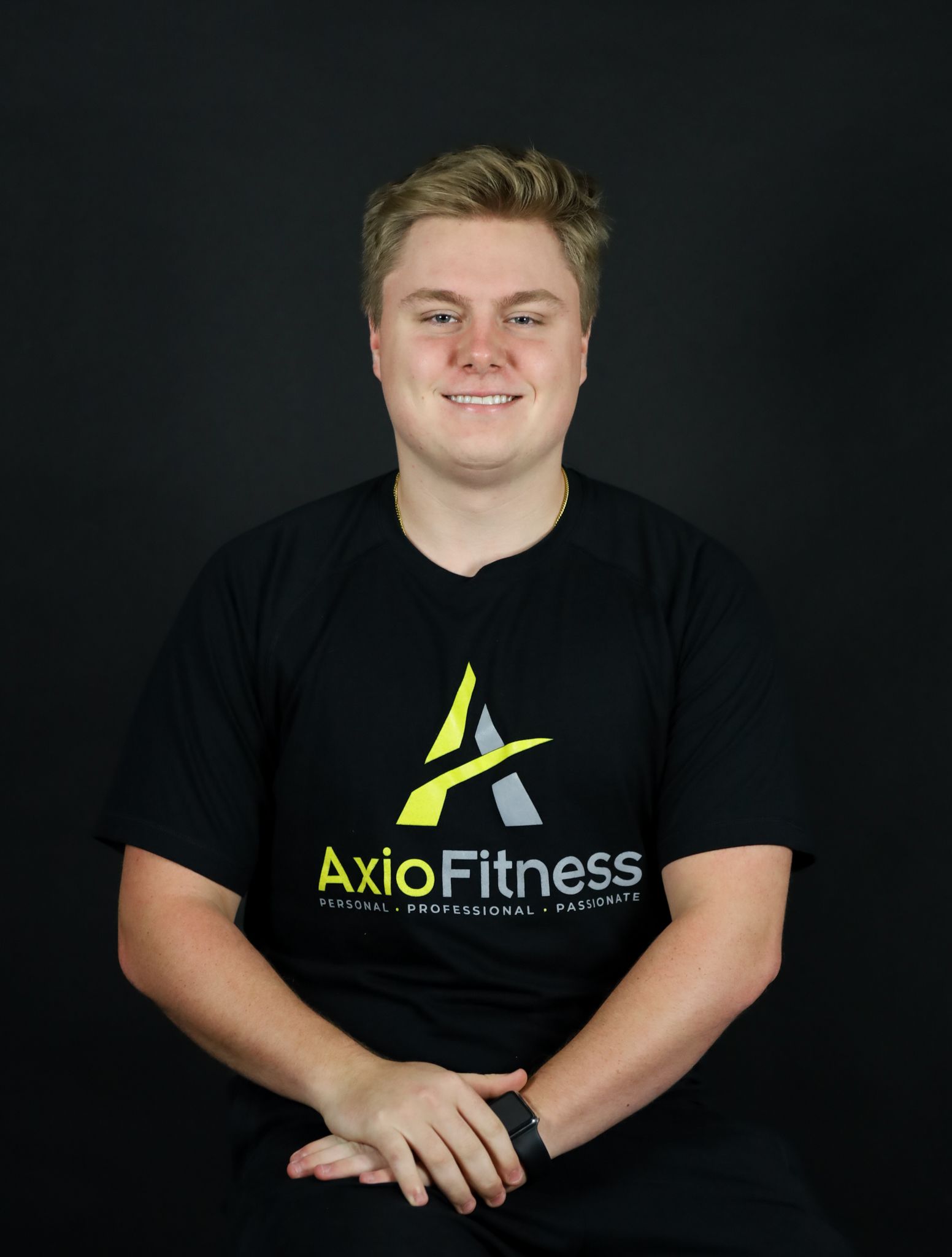 A young man with blonde hair, wearing a black t-shirt with 