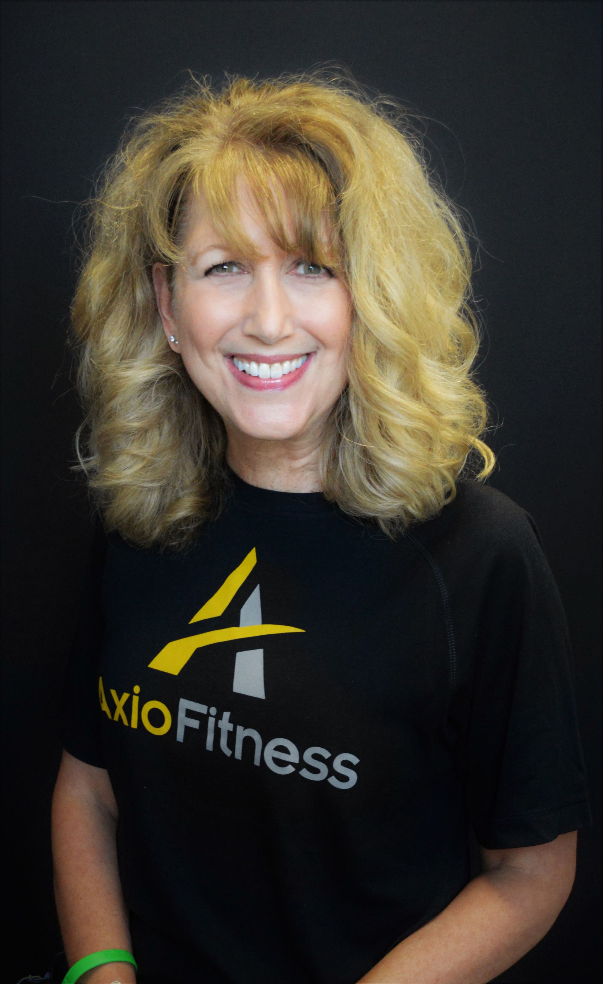 Woman with blonde curly hair wearing a black 