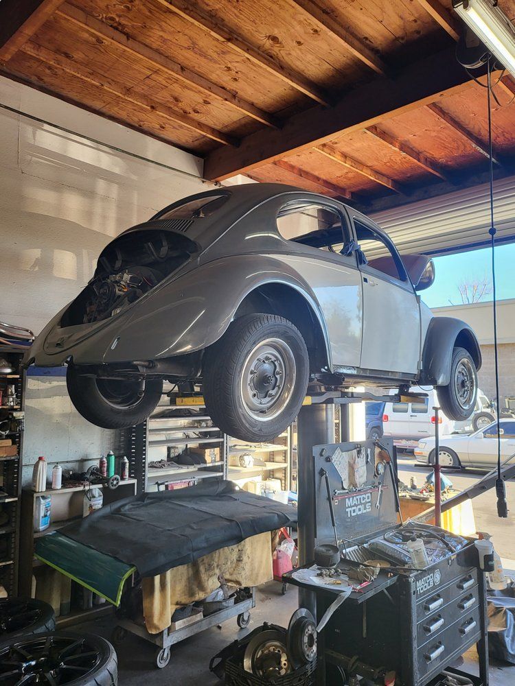 A car is sitting on a lift in a garage.