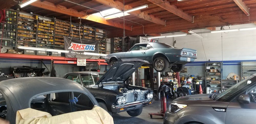 A car is sitting on a lift in a garage.