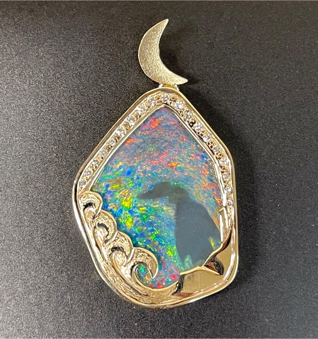 A pendant with a crescent moon on top of it