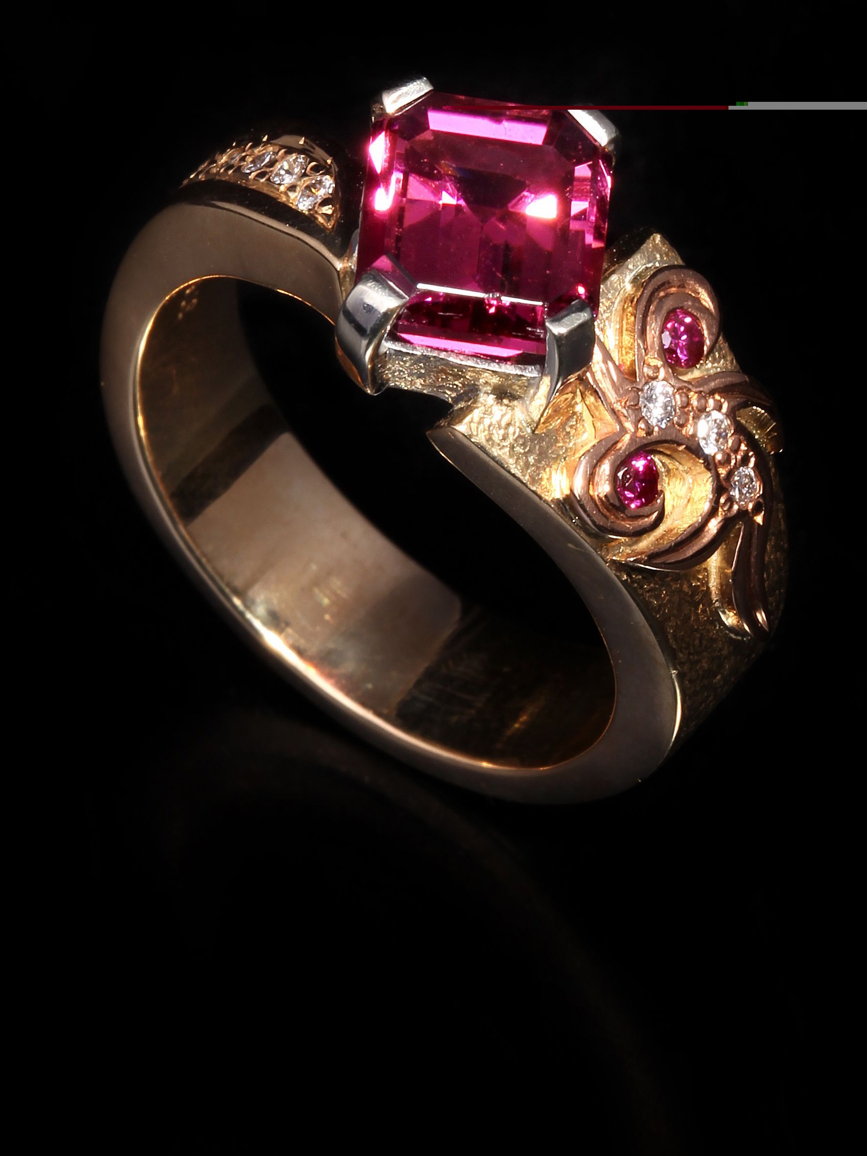A gold ring with a pink stone in the center