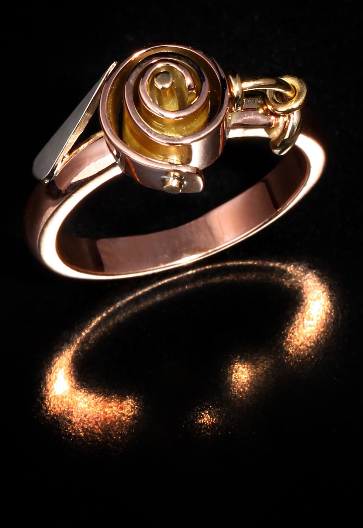 A gold ring with a spiral in the center on a black background