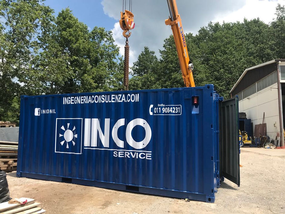 Container blu sollevato da una gru all'aperto, con il logo INCO SERVICE sul lato.