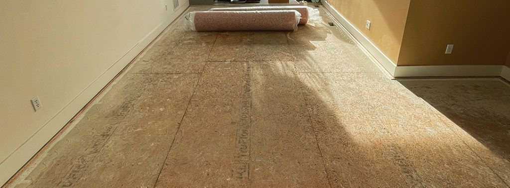 A long hallway with rolls of carpet on the floor.