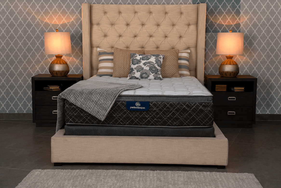 Una cama con colchón y almohadas en un dormitorio.