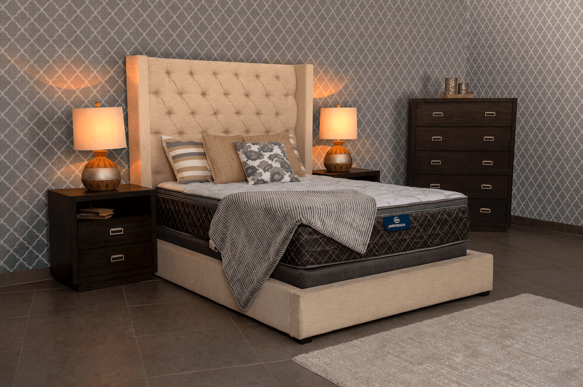 Un dormitorio con cama , cómoda , mesita de noche y lámparas.