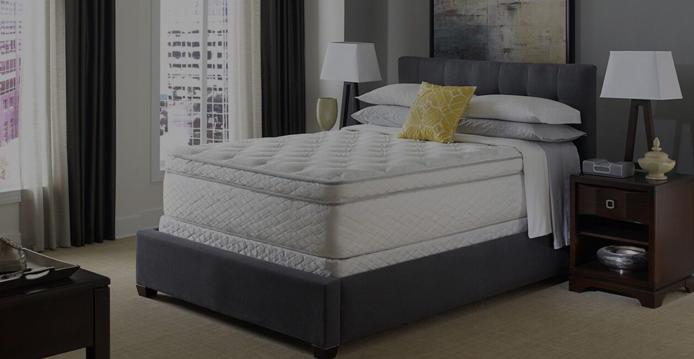 Una cama con colchón y almohadas en un dormitorio.