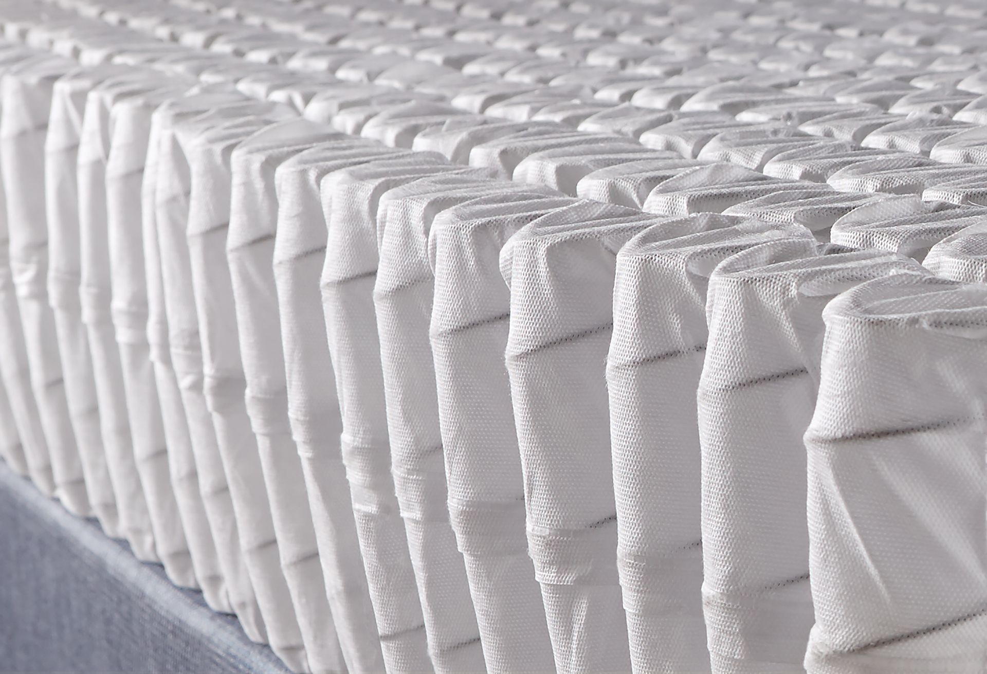 Un primer plano de un colchón blanco en una cama.