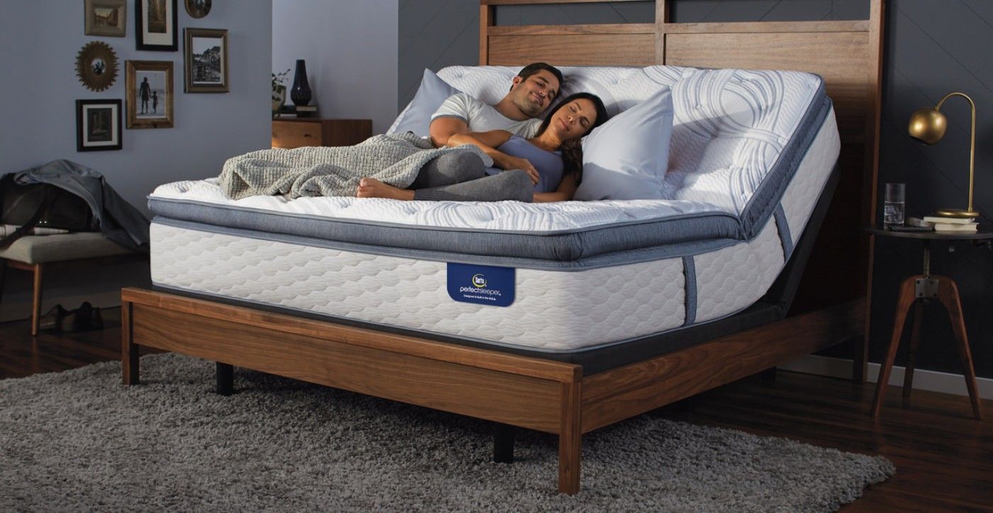 Un hombre y una mujer están tumbados encima de una cama ajustable.