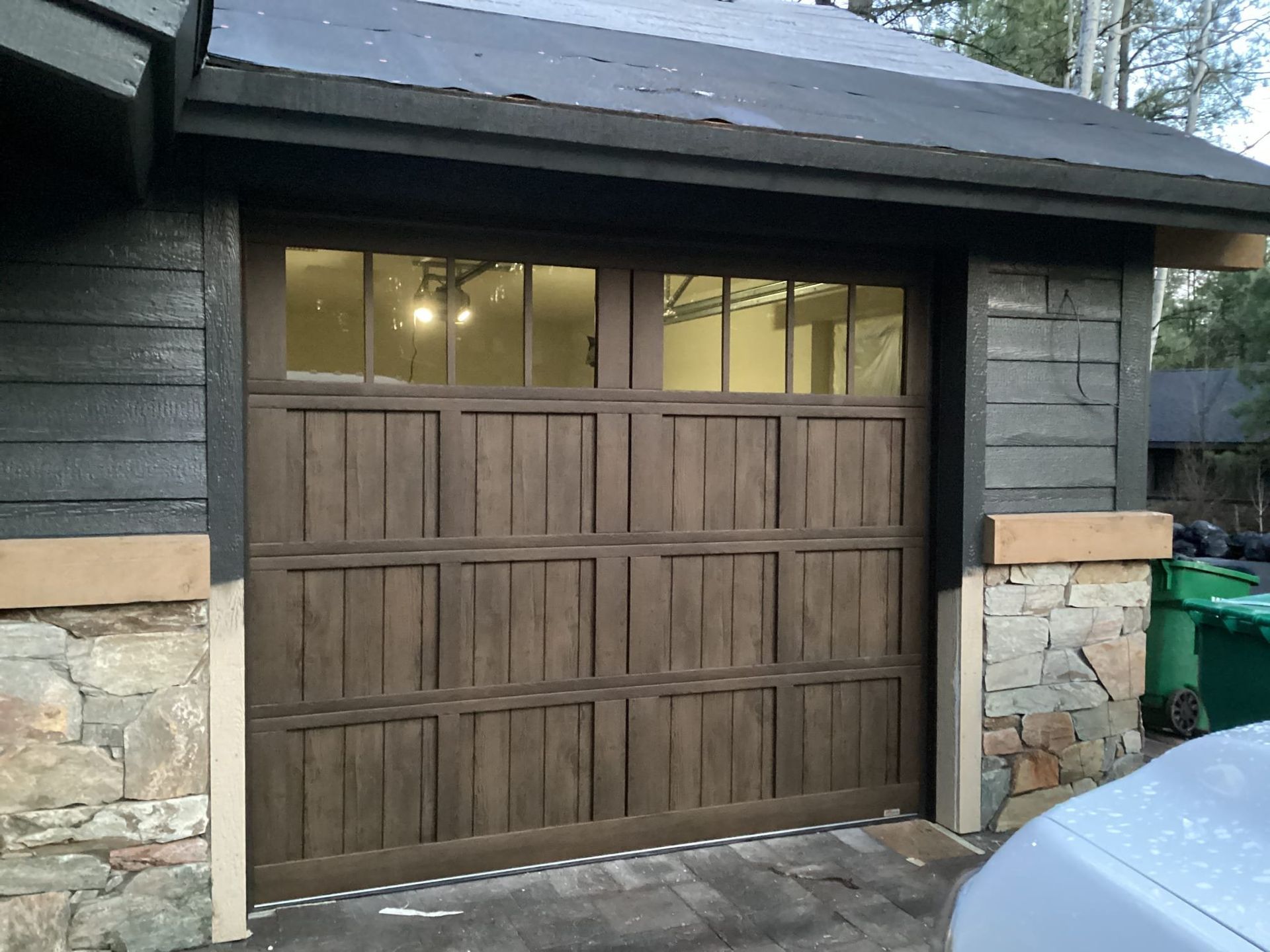 A car is parked in front of a wooden garage door