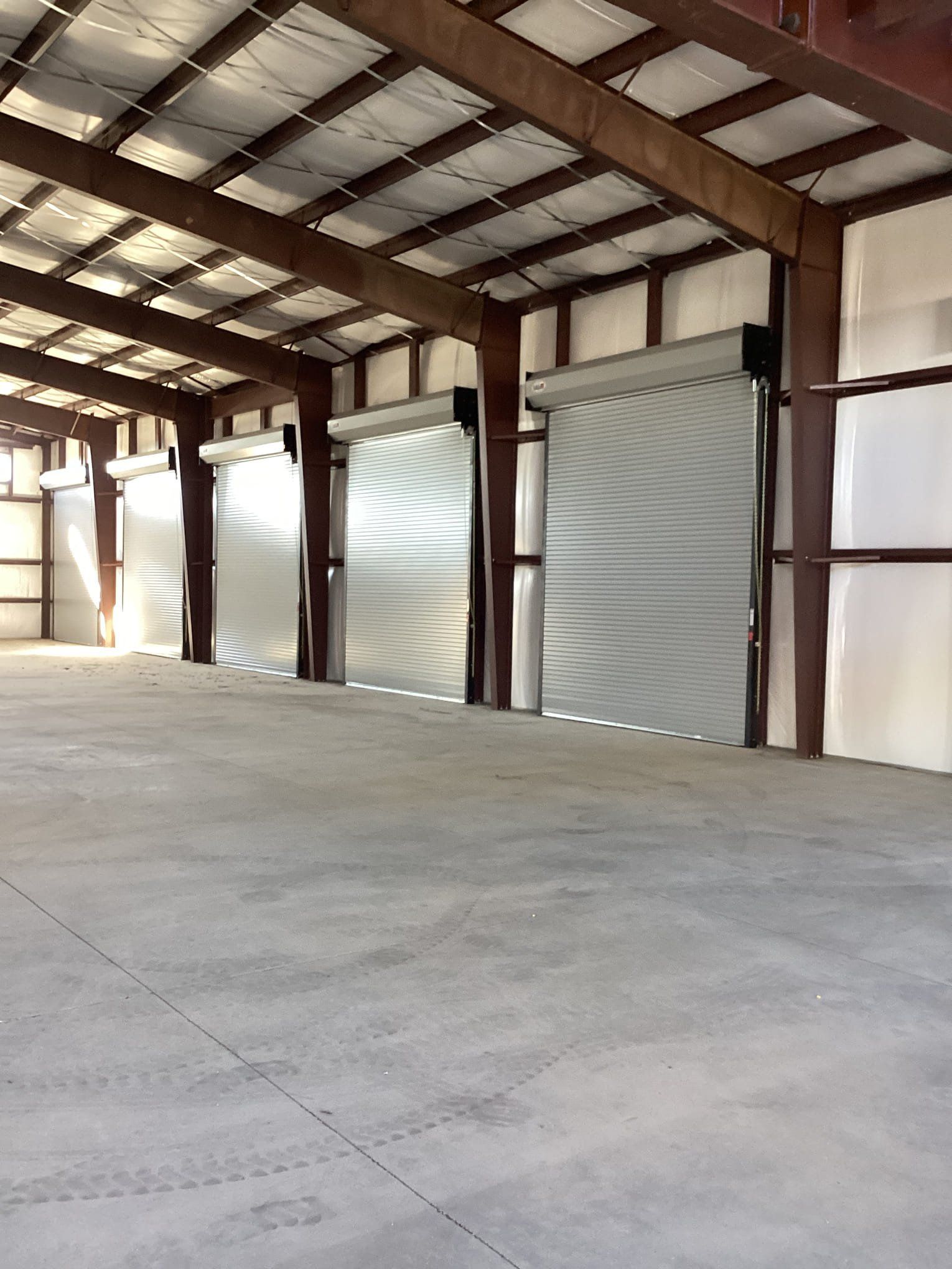 A large warehouse with a lot of doors and a concrete floor