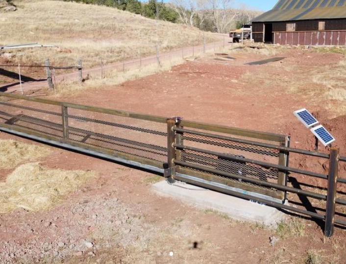 A sliding gate with a solar panel attached to it.