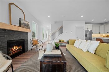 Spacious living room with stone fireplace and can lighting above