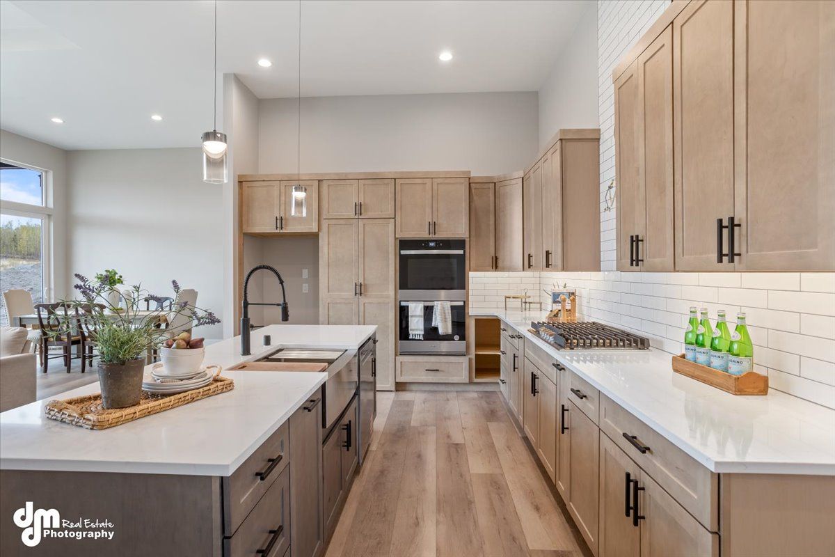 Bright modern kitchen with wood cabinets, white countertops, island, and stainless steel appliances