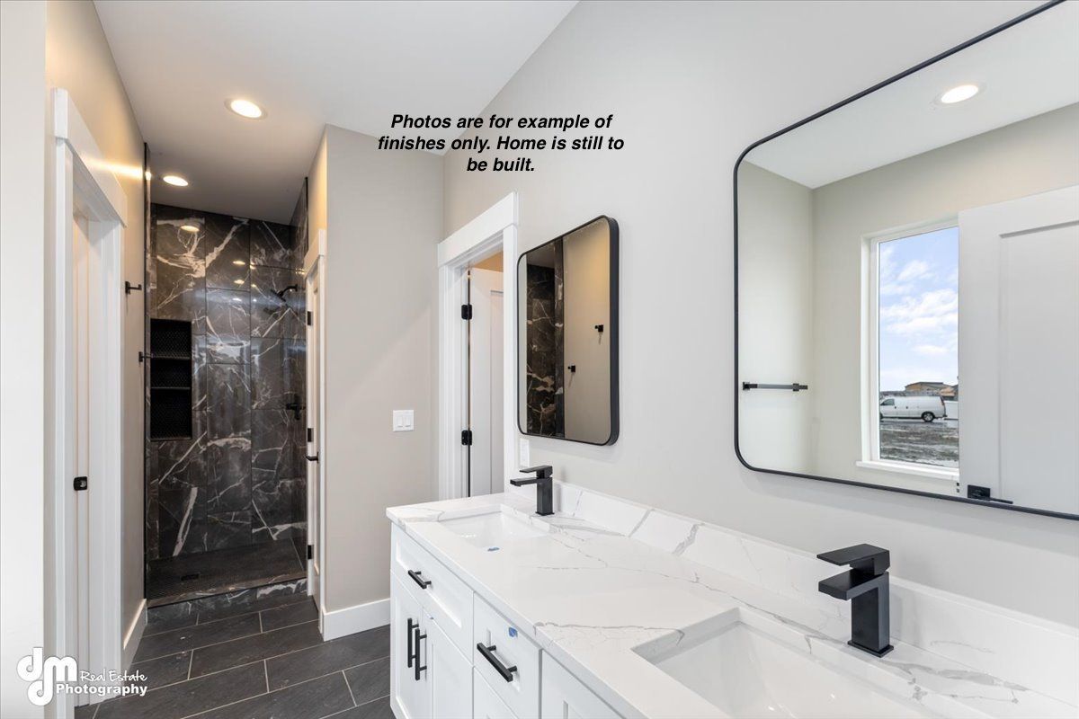 Modern bathroom with double vanity, black fixtures, large mirror, and tiled shower corridor