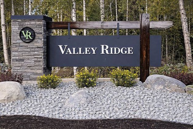 Valley Ridge neighborhood entrance sign with stone pillars, wood accents, and landscaping gravel.