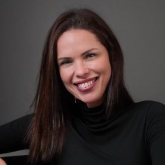 Woman with dark hair, smiling at camera, wearing a black turtleneck.