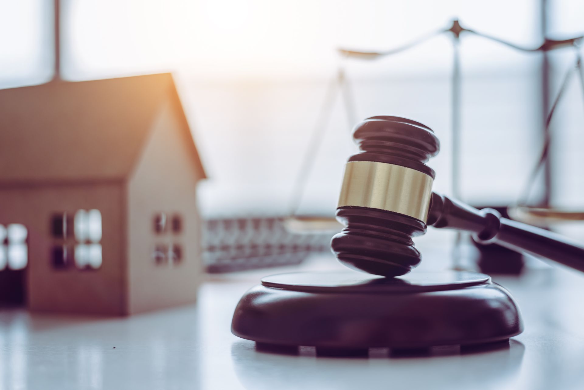 Judge's gavel beside a model house and scales, symbolizing real estate law. Judge's gavel beside a model house and scales, symbolizing real estate law.