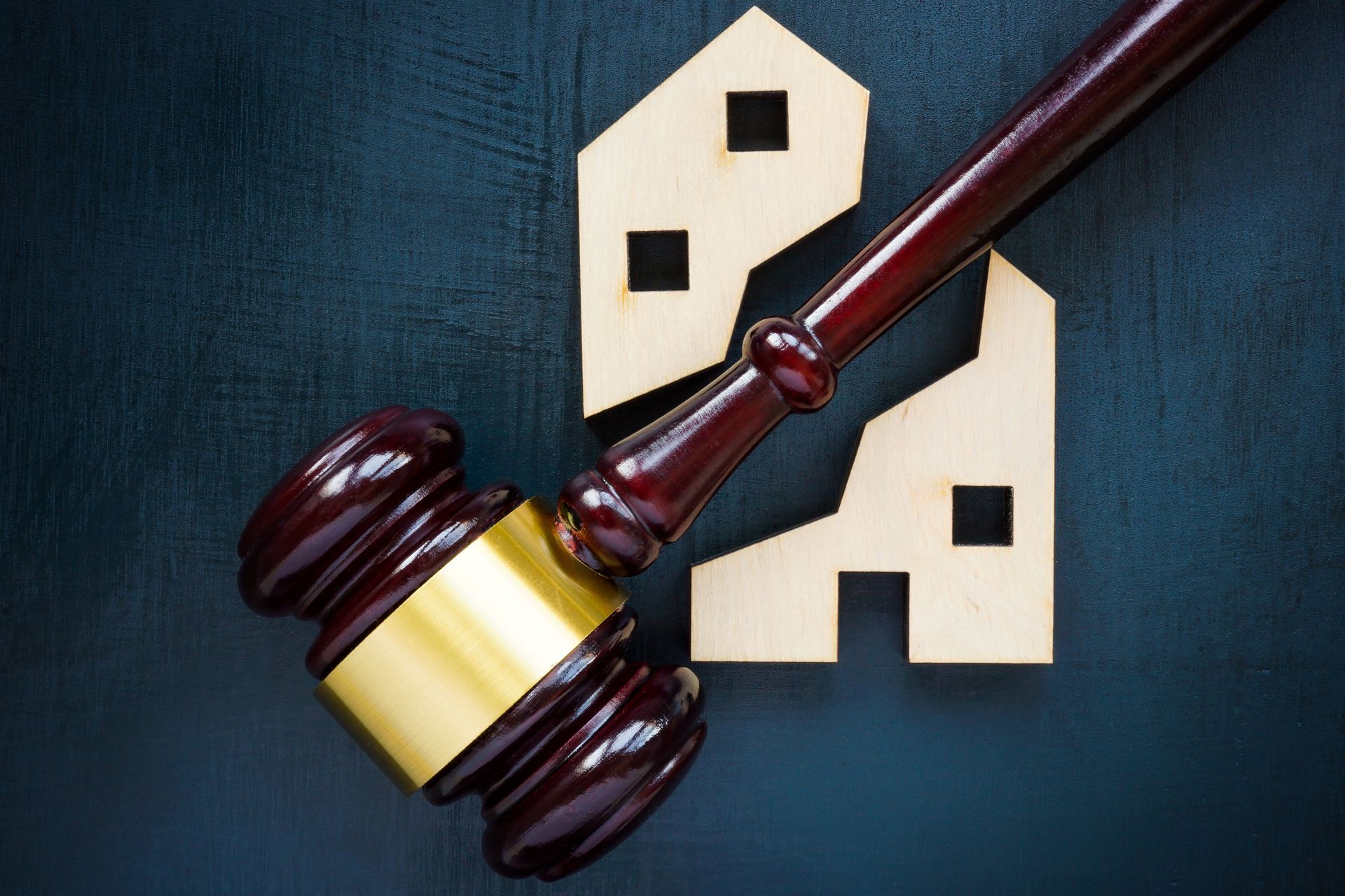 Judge's gavel over a house symbol, representing real estate law or property disputes.
