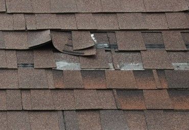 Asphalt shingle residential roof wind damage in Atlanta, Georgia.