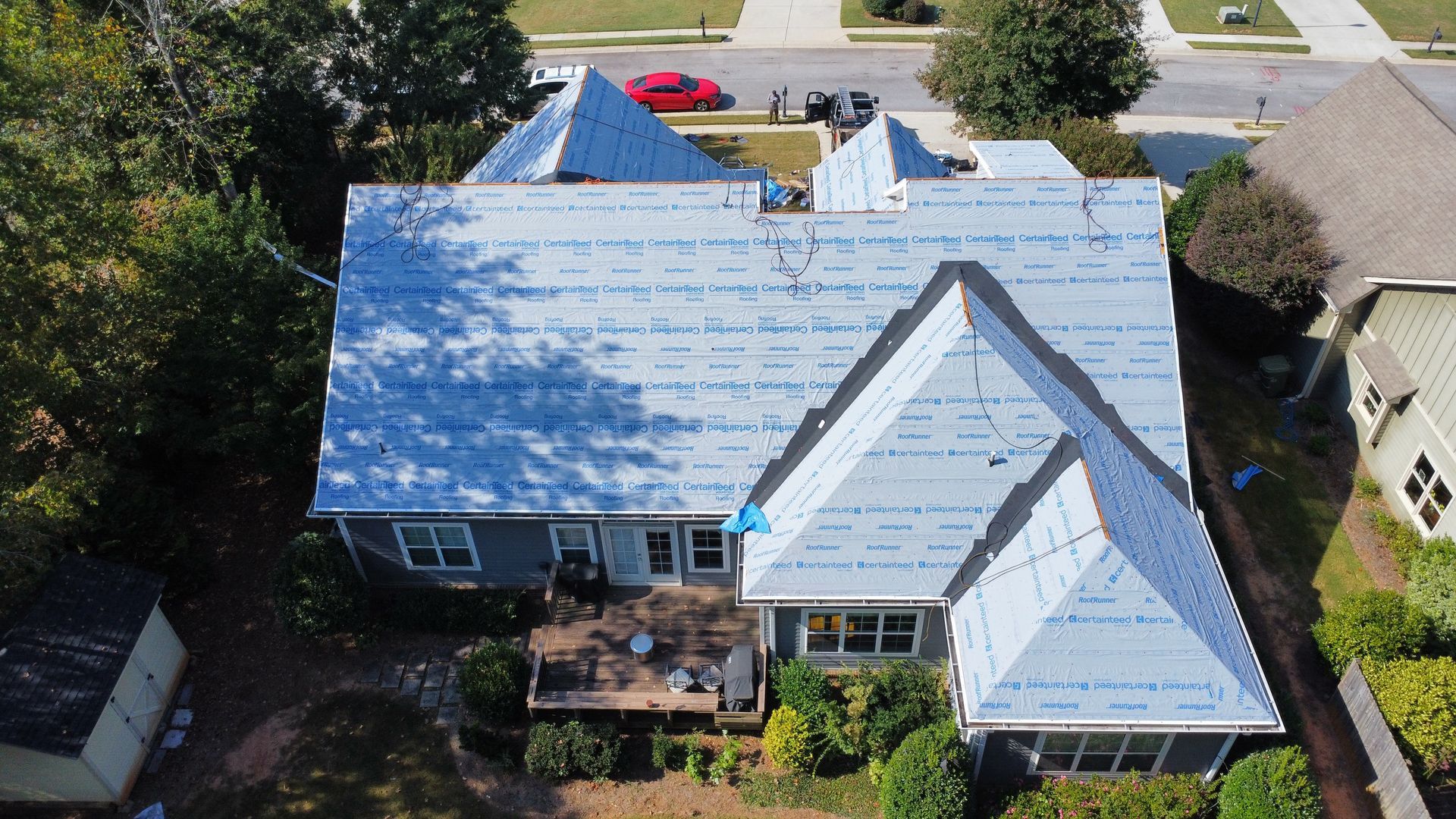 Merck Roofing crew members replacing damaged composite shingles on a Jackson County, Georgia property.