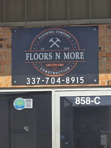 Storefront sign for “Floors N More” with phone number 337-704-8915 above door 858-C