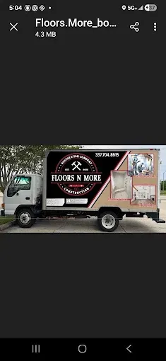 White truck with a black-and-red “FLOORS N MORE” flooring service ad on the side.