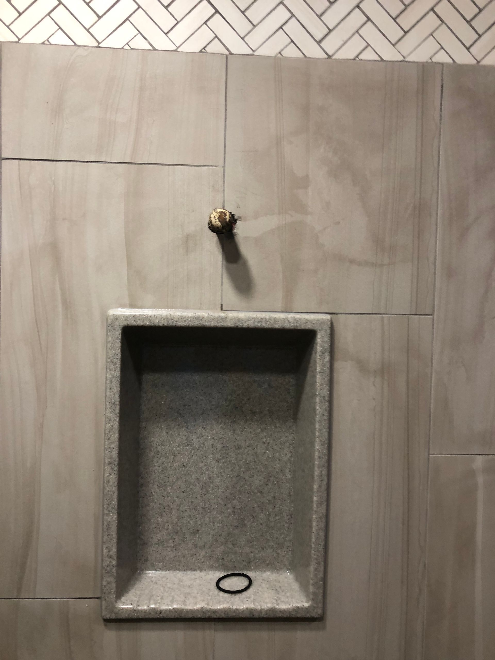 Stone wall with a recessed sink basin and a faucet above it.