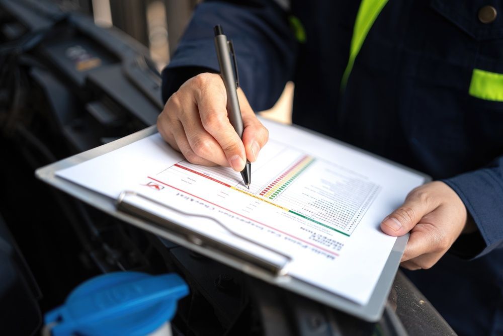 Hands writing on a clipboard with a pen beside a colorful chart
