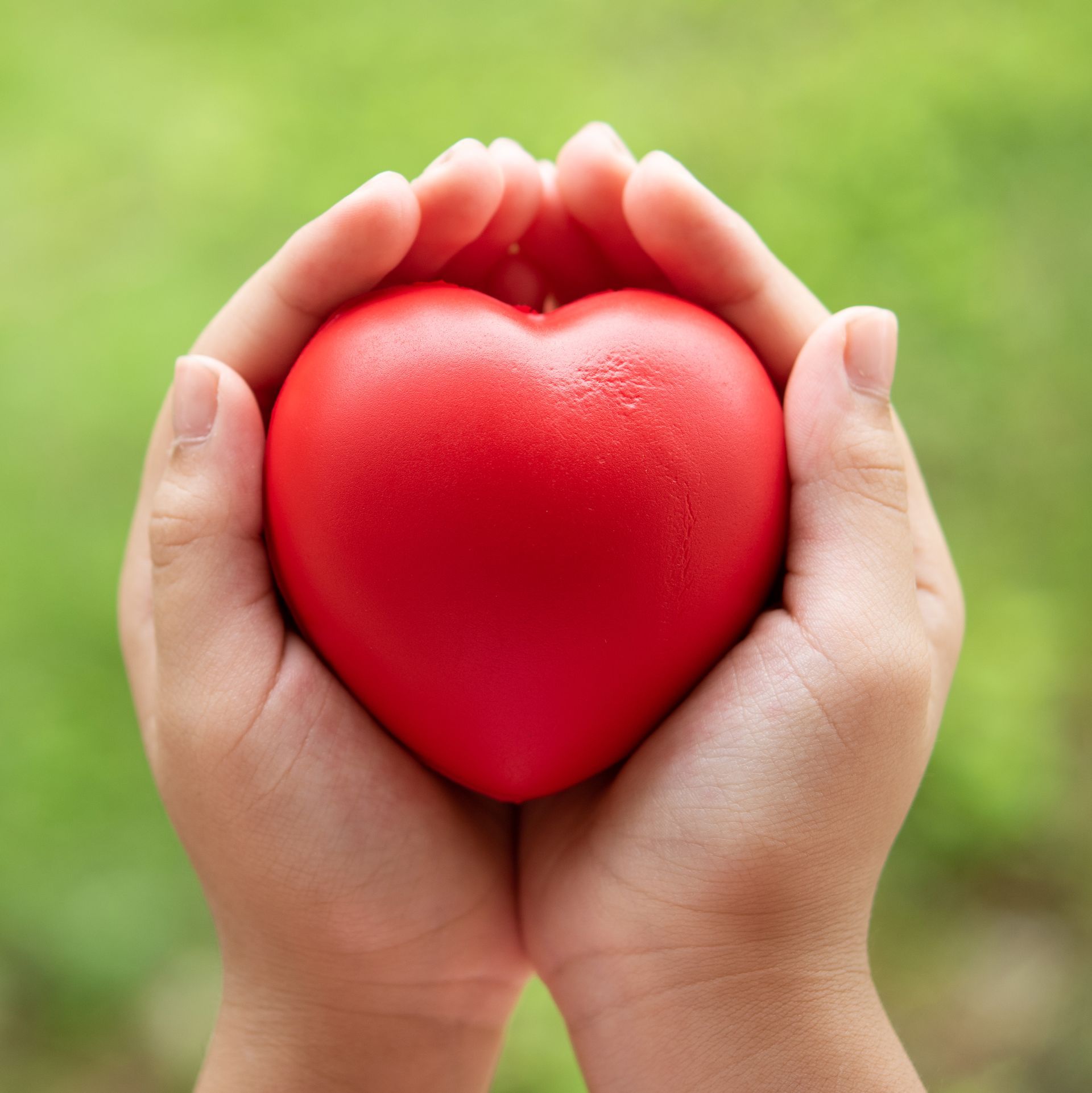 Child holding a red rubber heart symbolizing heart health awareness for women.