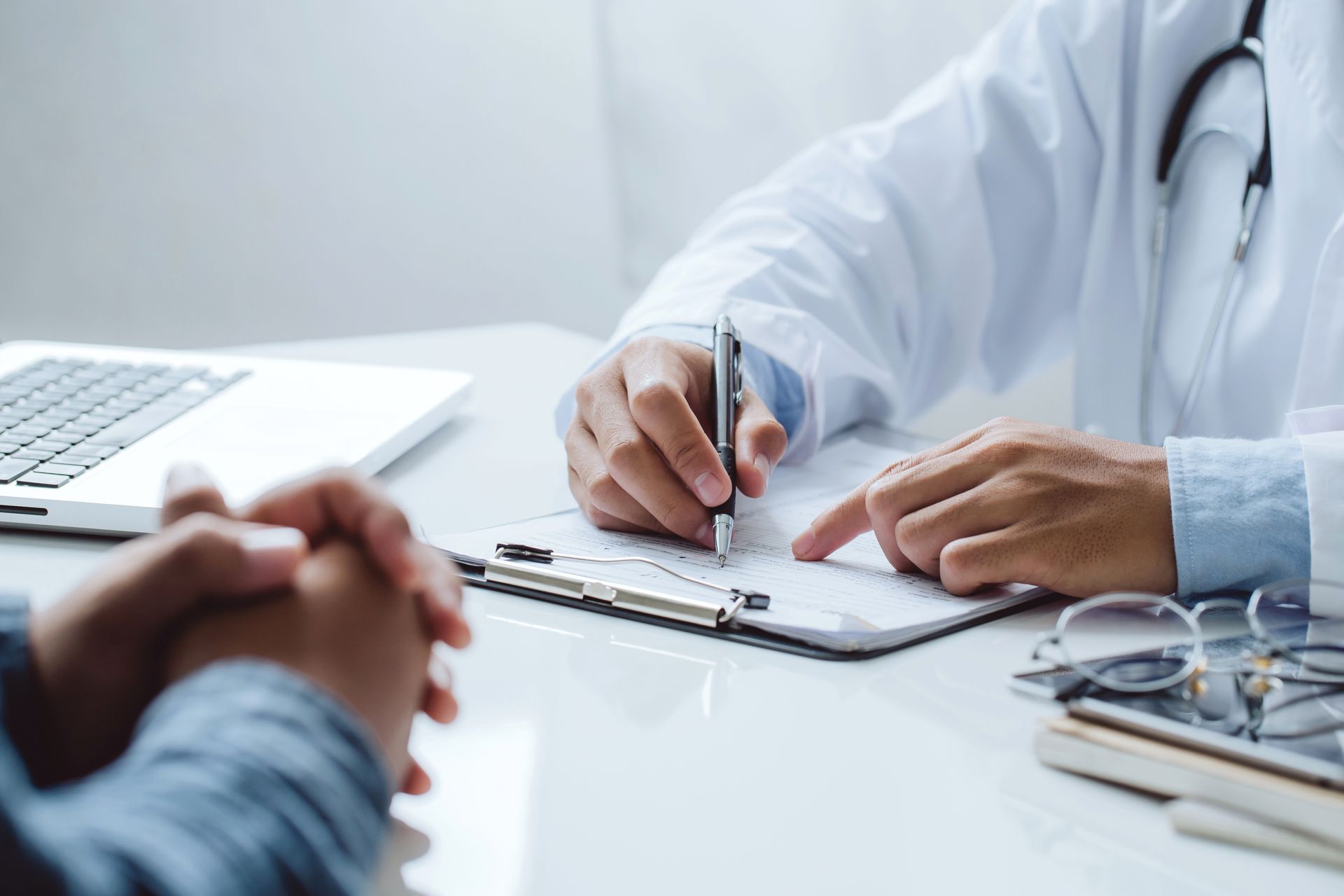Doctor discussing patient consultation, reviewing medical symptoms and treatment options.