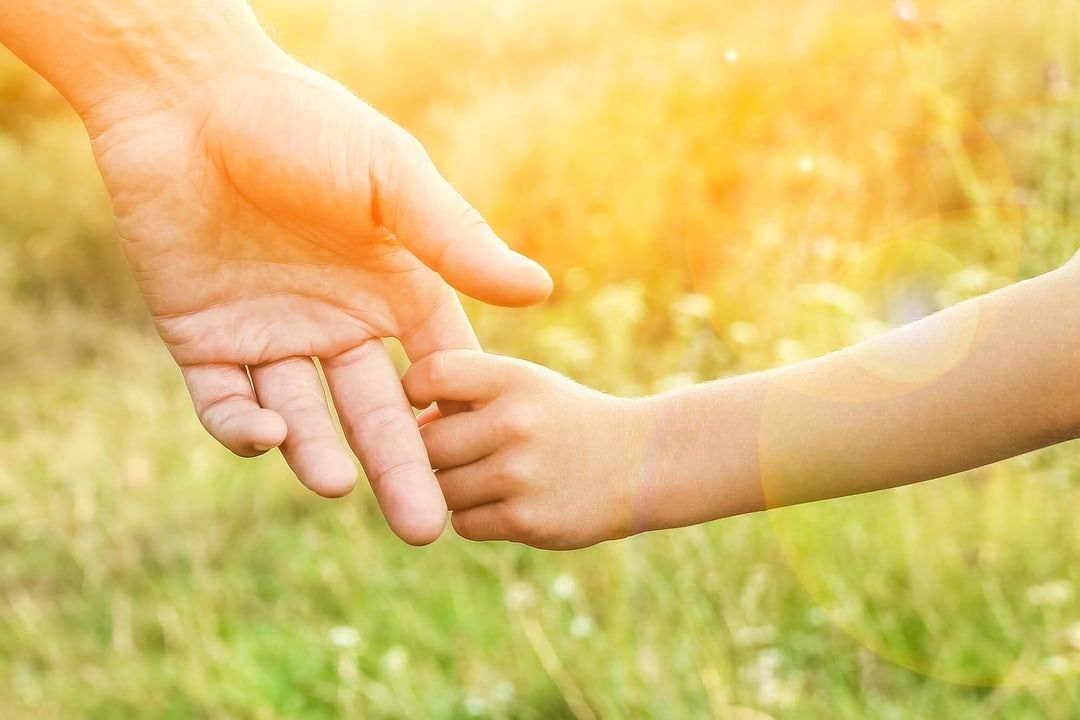child and parent holding hands