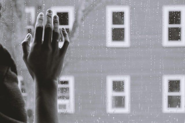 person holding hand on window